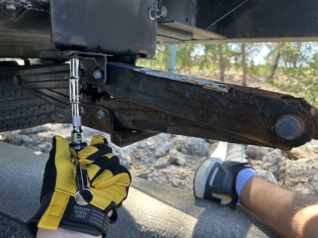 Removing the old stabilizer jack with a ratchet.